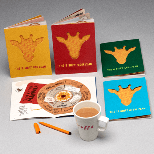 Colourful giraffe-themed notebooks beside a coffee mug